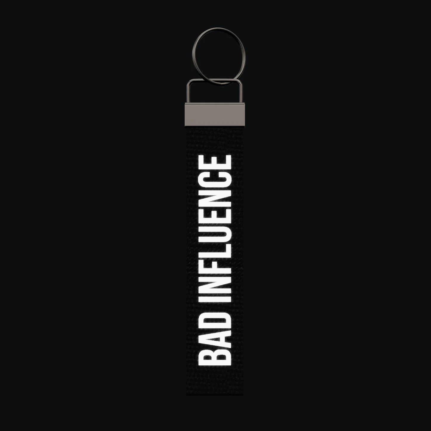 BAD INFLUENCE Keychain, reflective print lit up by a camera flash