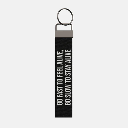 GO FAST TO FEEL ALIVE, GO SLOW TO STAY ALIVE Keychain, front: GO FAST TO FEEL ALIVE, GO SLOW TO STAY ALIVE in white print