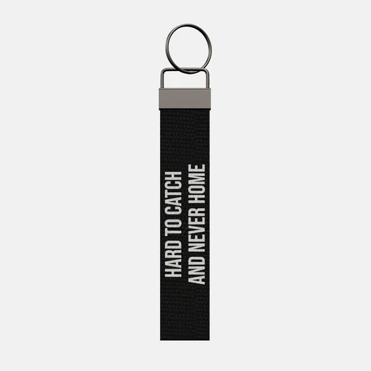 HARD TO CATCH AND NEVER HOME Keychain, front: HARD TO CATCH AND NEVER HOME in white print