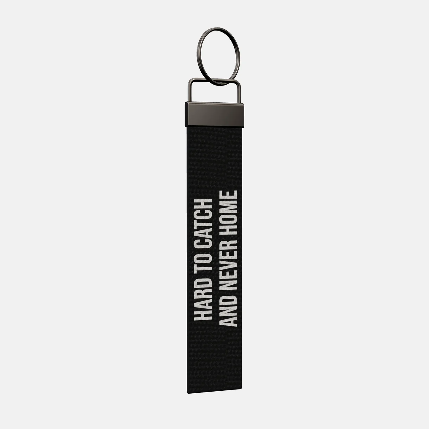 HARD TO CATCH AND NEVER HOME Keychain at an angle, black-nickel clamp and split ring