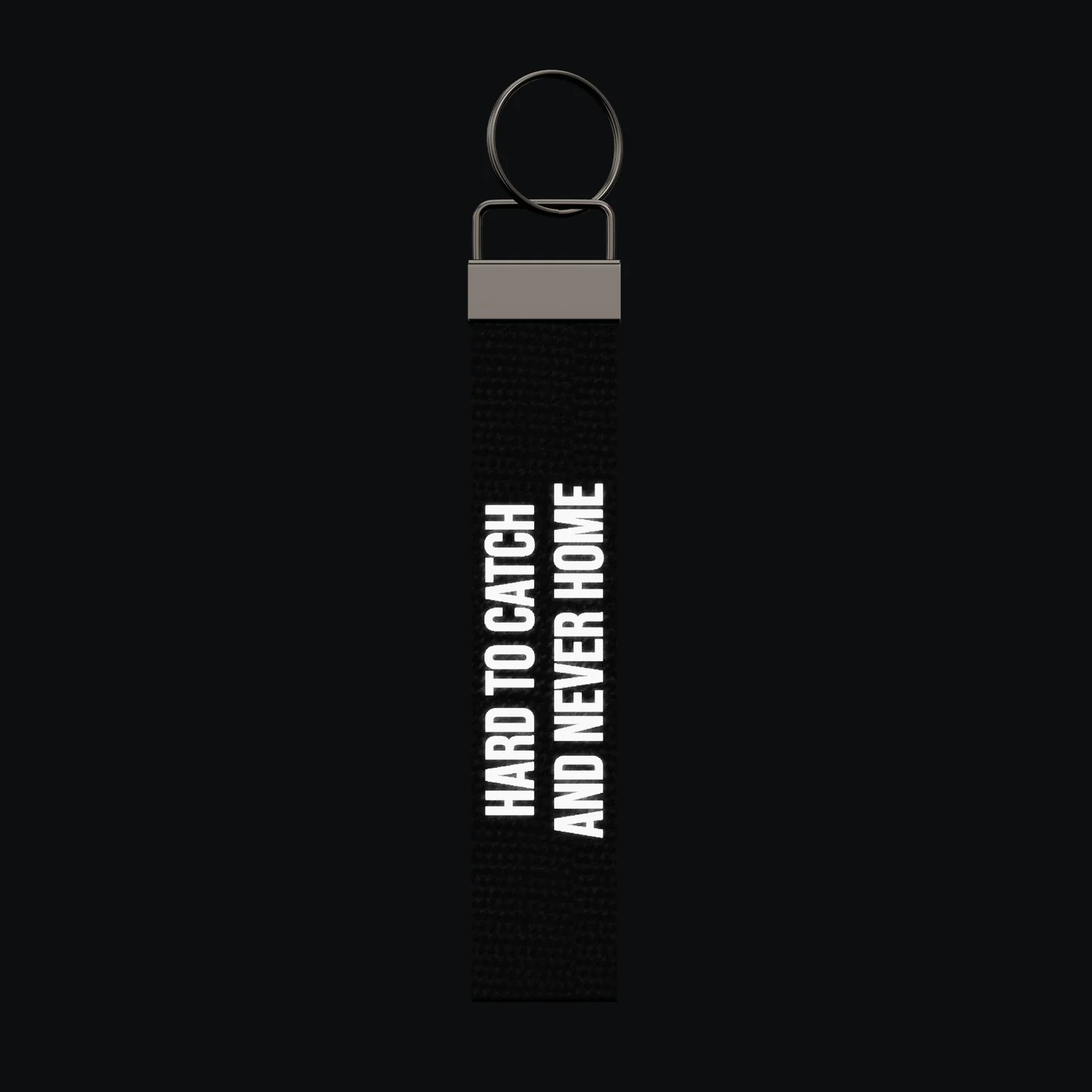 HARD TO CATCH AND NEVER HOME Keychain, reflective print lit up by a camera flash