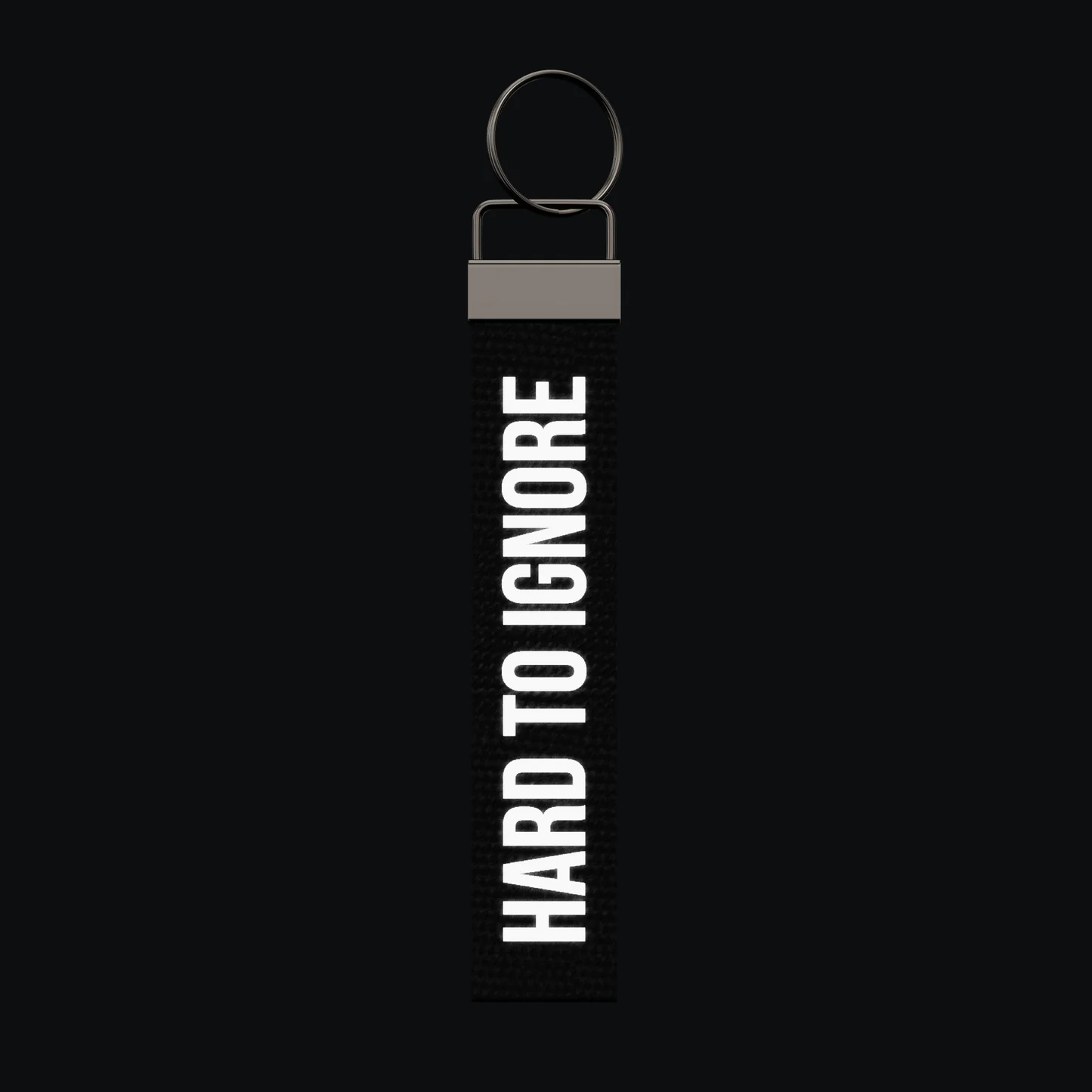 HARD TO IGNORE Keychain, reflective print lit up by a camera flash