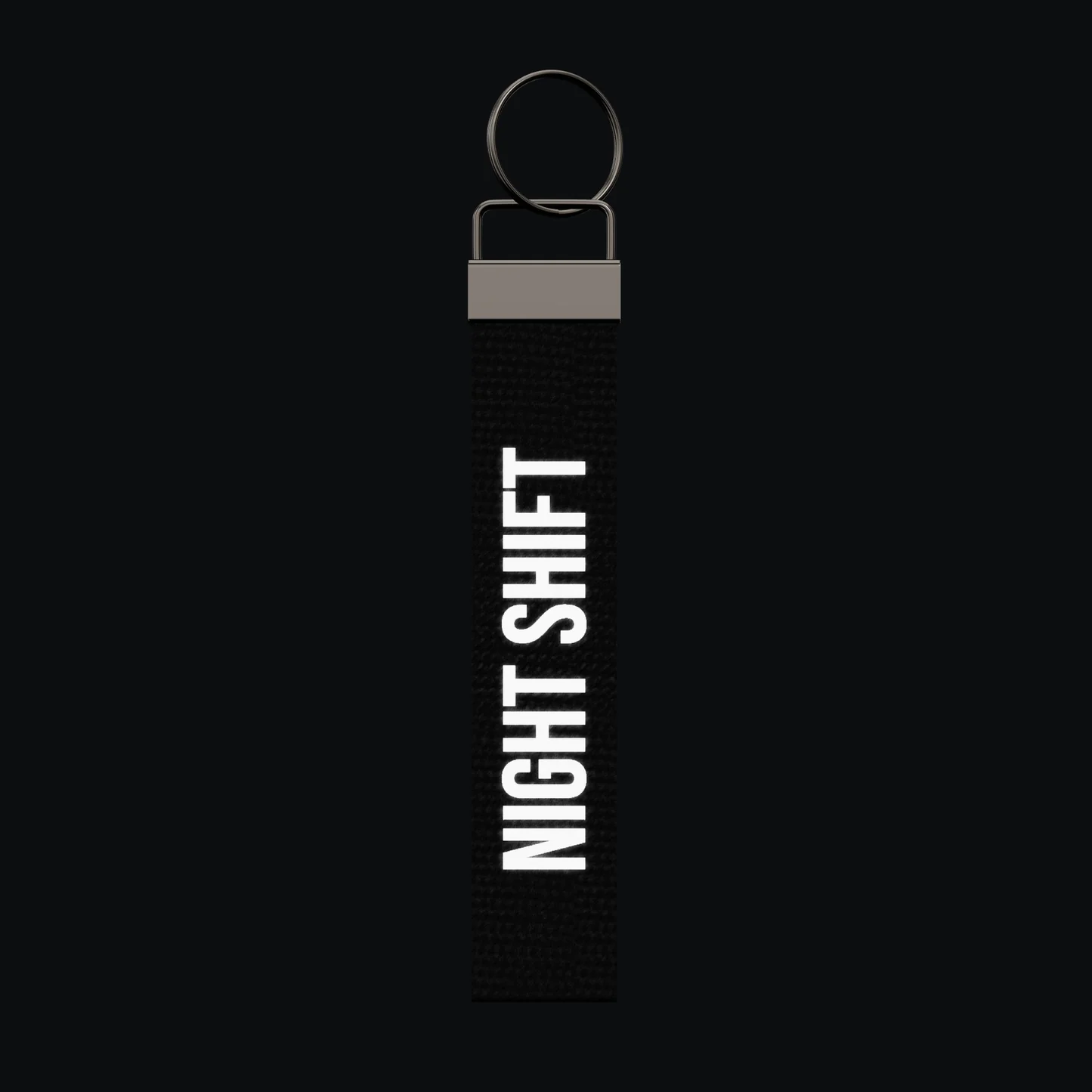 NIGHT SHIFT Keychain, reflective print lit up by a camera flash