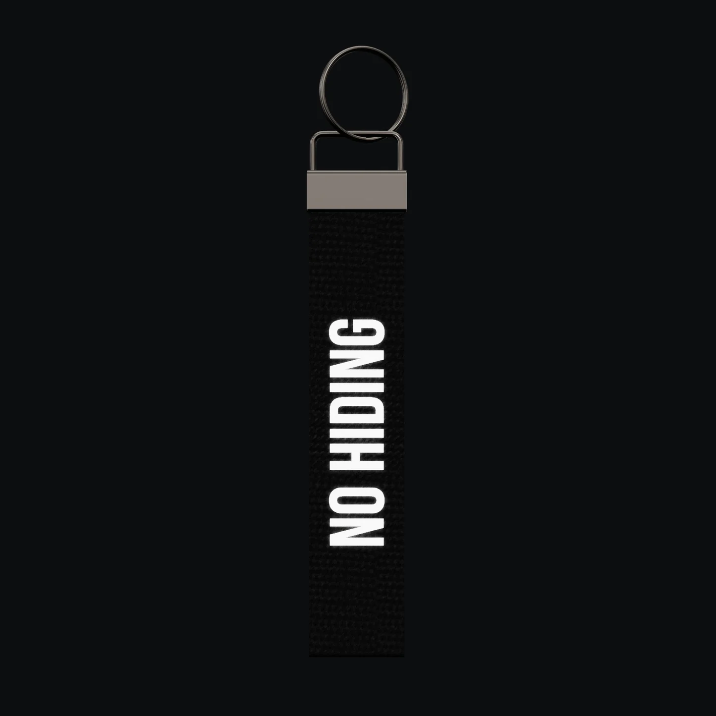 NO HIDING Keychain, reflective print lit up by a camera flash