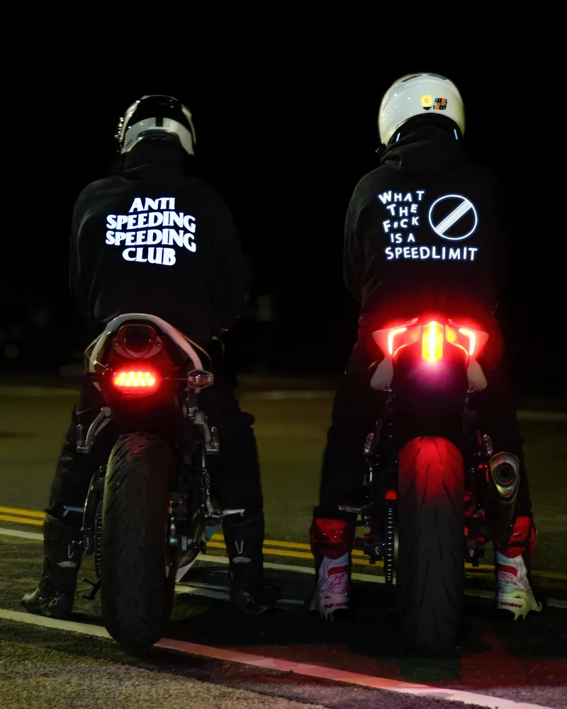 ANTI SPEEDING SPEEDING CLUB and WHAT THE F#CK IS A SPEEDLIMIT prints glowing in headlights at night