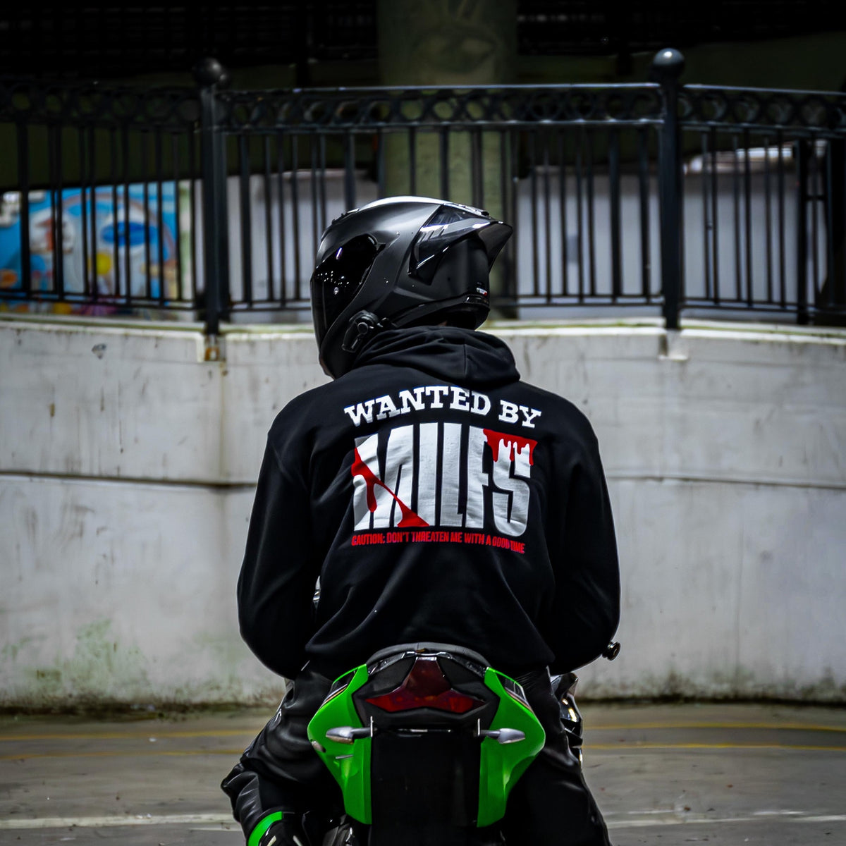 Rider wearing the WANTED BY MILFS Hoodie, back print